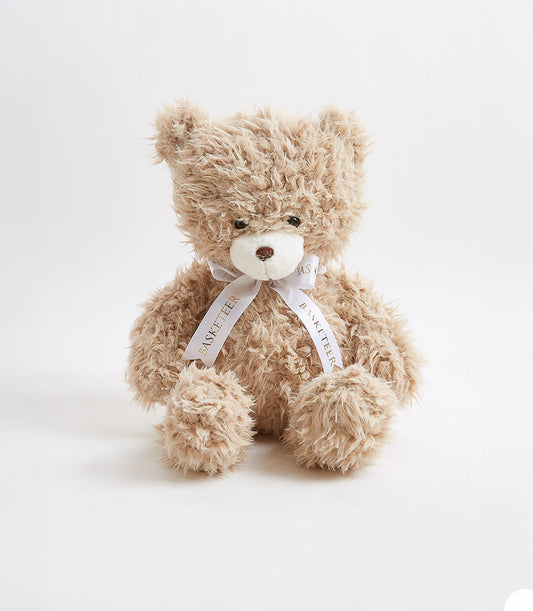 Soft light brown teddy bear with white satin ribbon bow, perfect for baby gifts and children