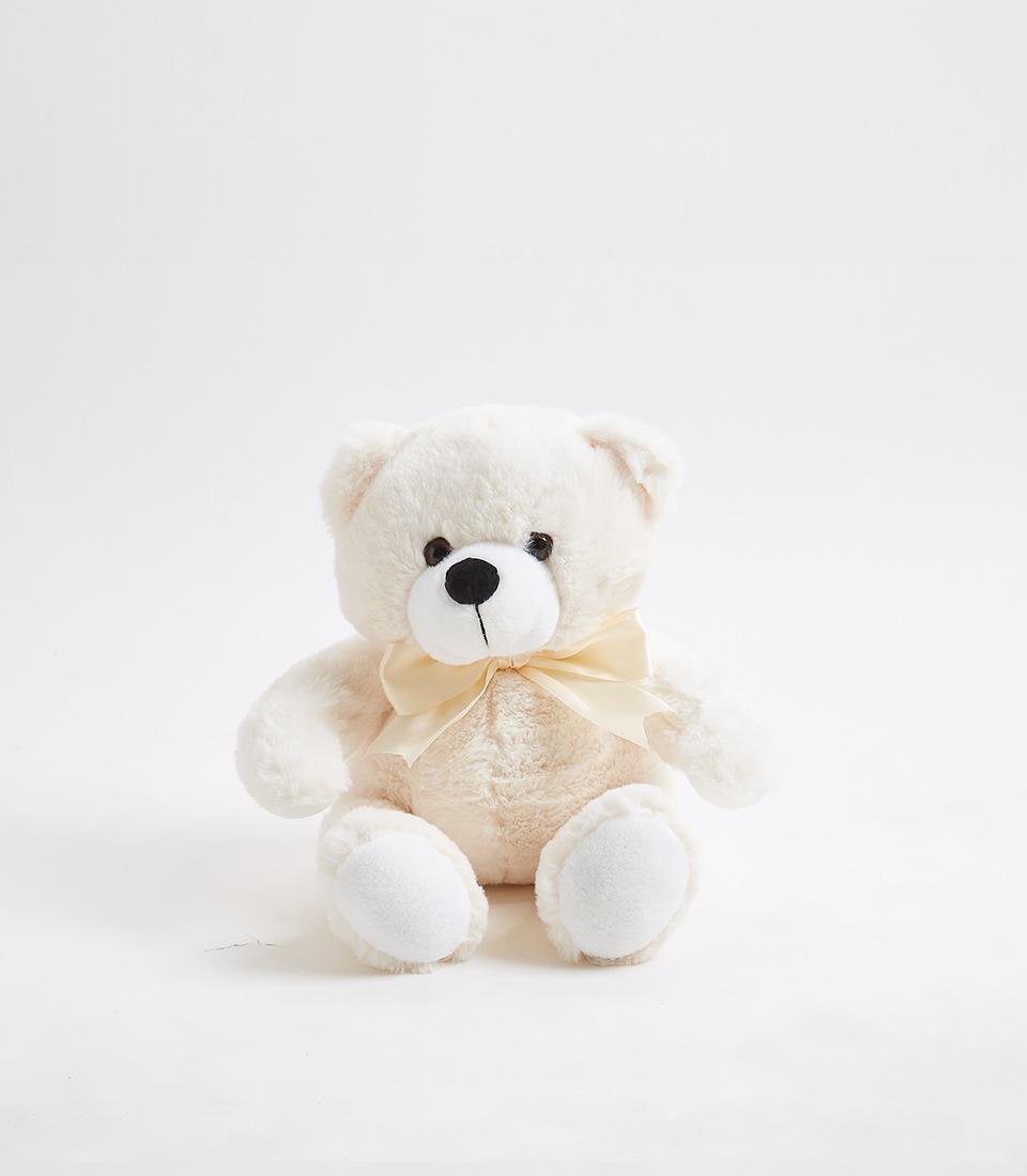 Creamy white plush teddy bear with satin bow, perfect for baby gifts and nursery cuddles