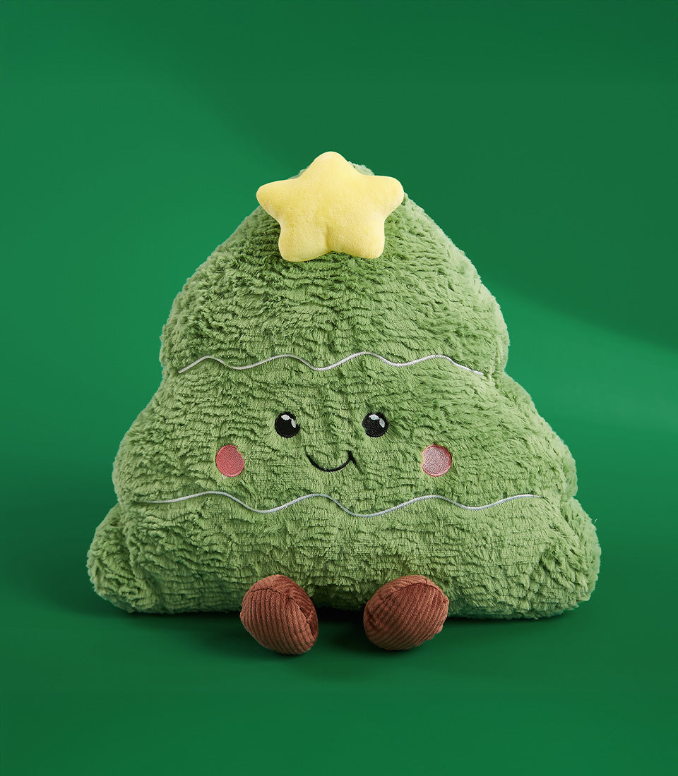 Plush green Christmas tree pillow with embroidered face, yellow star, and brown feet