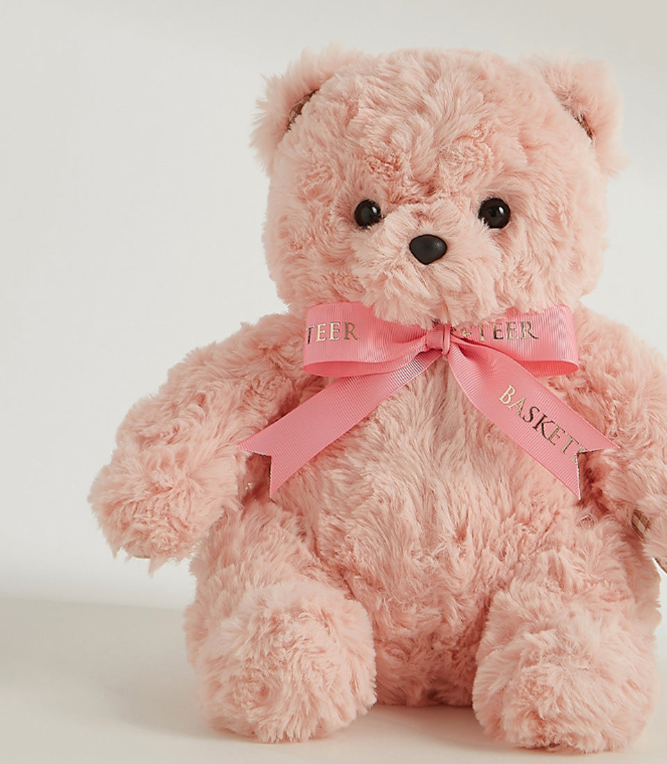 Soft pink plush teddy bear with satin ribbon bow, perfect for cuddly gift giving