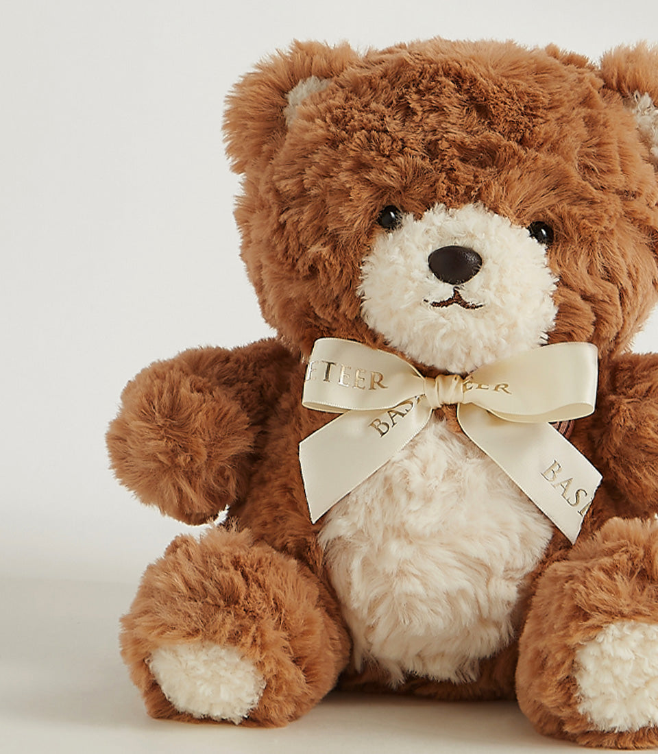 Plush brown teddy bear with cream-colored muzzle and satin ribbon bow, perfect for cuddly gifting