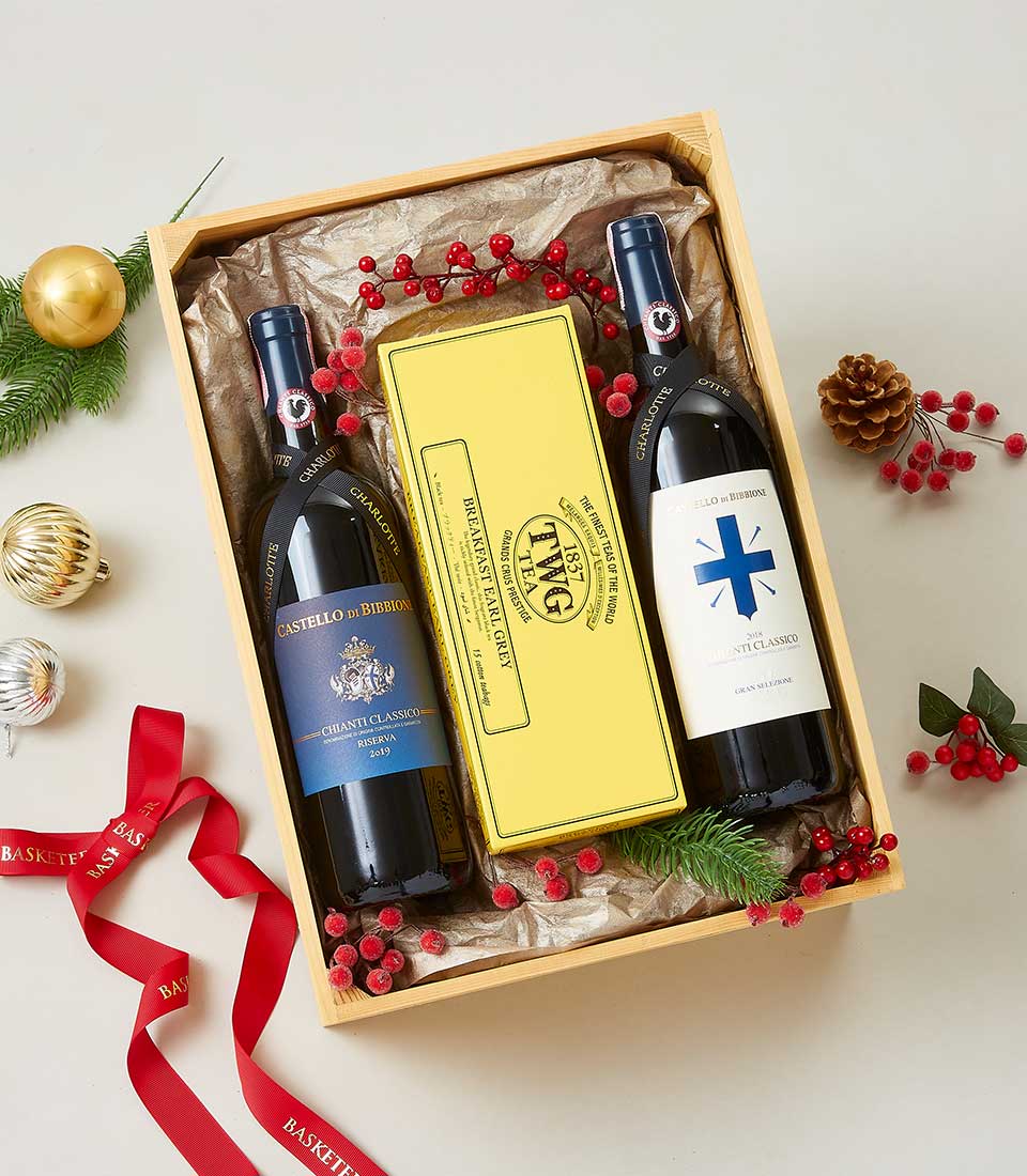 Premium Italian Chianti wines and TWG tea in festive wooden crate with holiday greenery and berries
