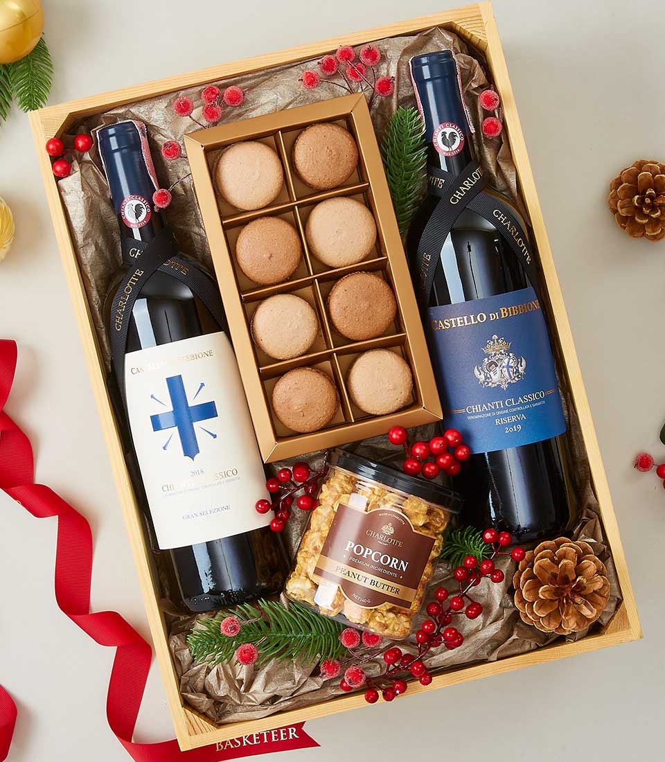 Chianti and Chardonnay wine gift box with macarons, popcorn, and festive red berry garnish in wooden crate