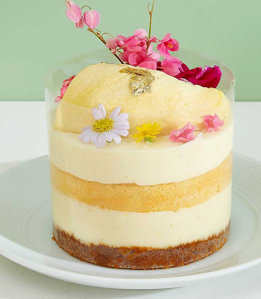 Mini layered durian cake with chocolate base, cream layers, and gold leaf in clear cup