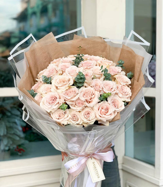 Light pink Mondial roses bouquet with eucalyptus, kraft paper and satin ribbon wrapping