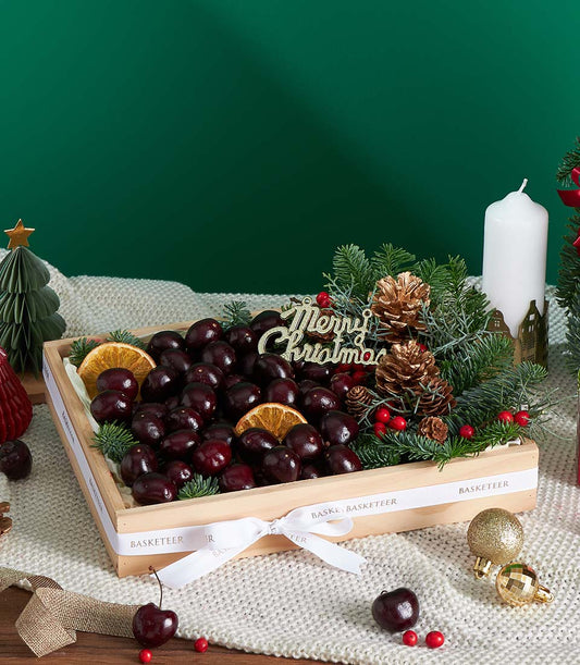 Premium cherry gift box with festive pine, dried citrus, and gold accents for Christmas