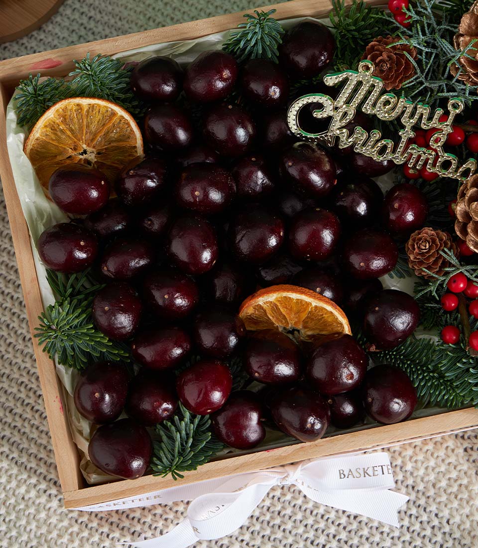 Premium dark chocolate-covered cherries in wooden gift box with festive dried citrus and pine, Christmas ribbon