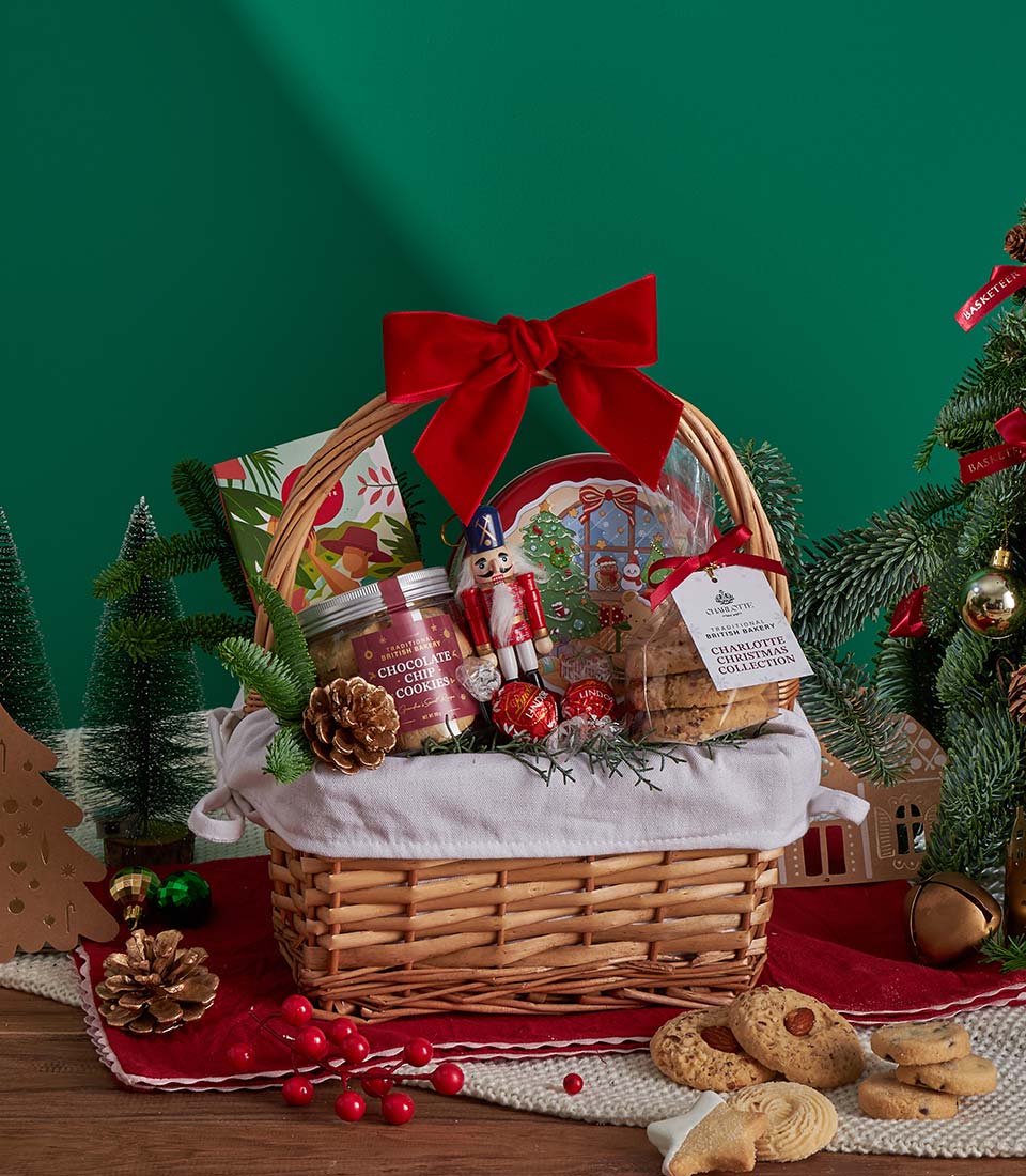 Festive wicker gift basket with Christmas cookies, chocolate truffles, and red velvet bow