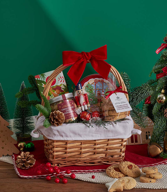 Festive wicker gift basket with Christmas cookies, chocolate truffles, and red velvet bow