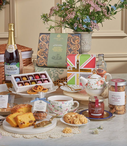 Deluxe British teatime gift set with sparkling beverages, artisan chocolates, Twinings tea, and gourmet baked goods for New
