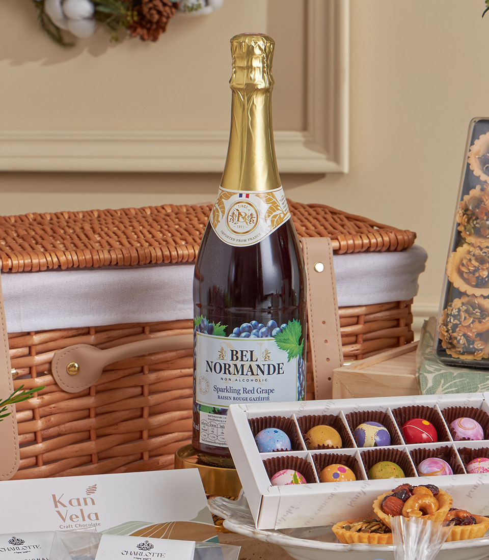 Deluxe teatime gift basket with sparkling red grape beverage, artisan chocolates, and gourmet tarts in wicker hamper for New