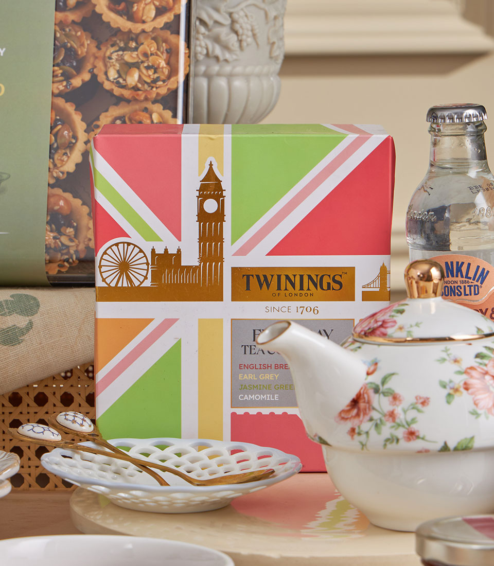 Deluxe Teatime Celebration gift set with Union Jack tea, ceramic teapot, floral teacup, golden spoons, and artisan tarts for