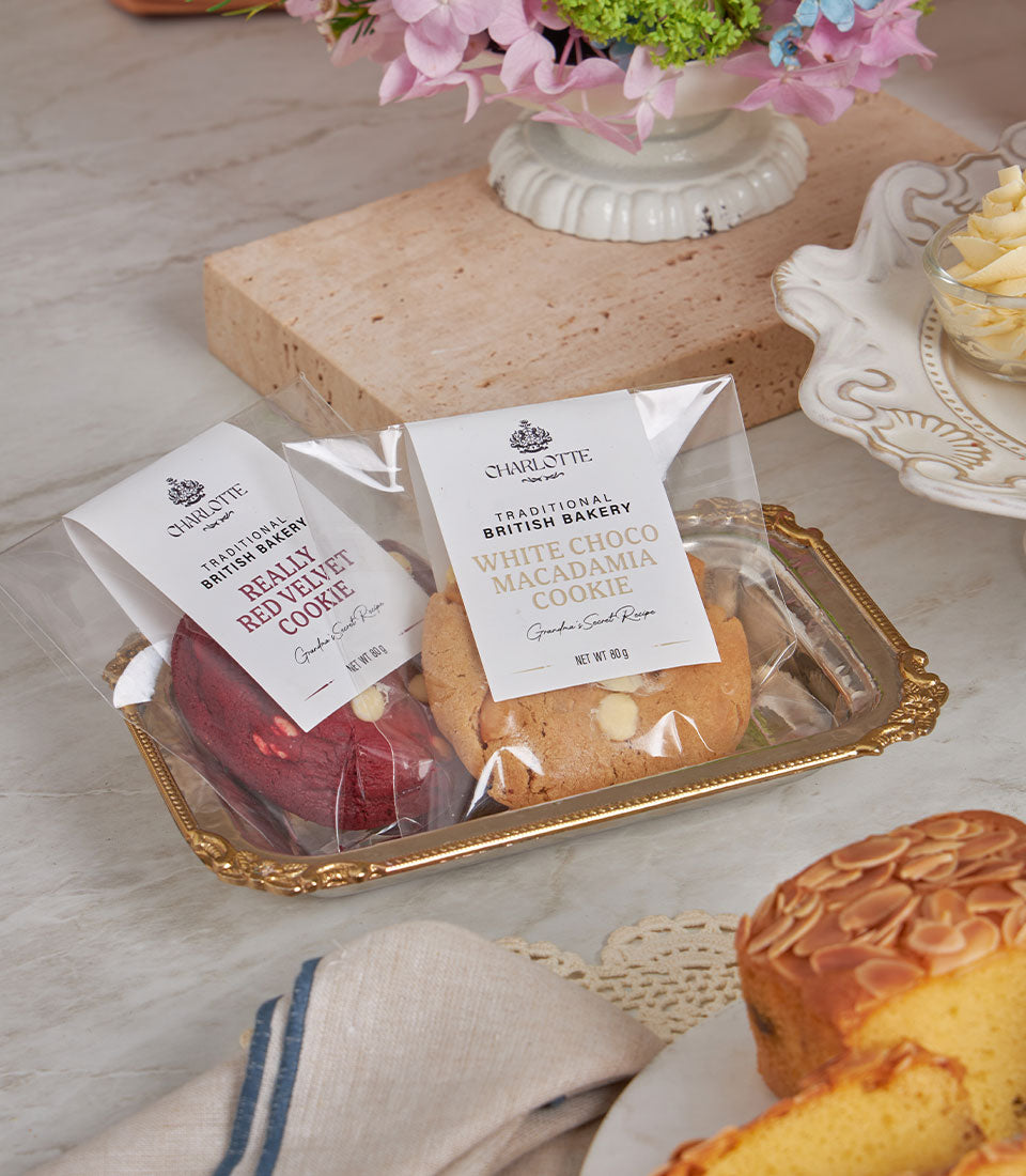 Luxury afternoon tea gift set with red velvet and white chocolate macadamia artisan cookies on gold-rimmed tray