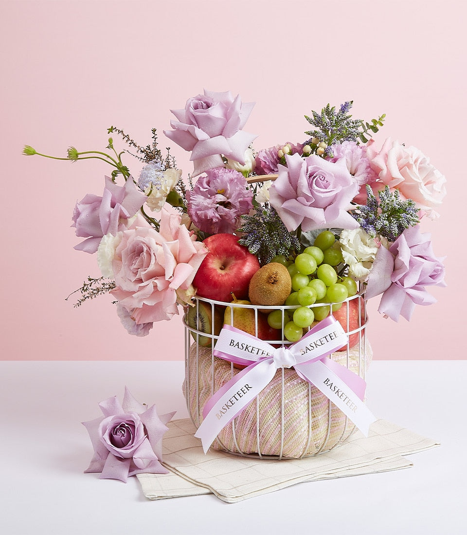 Purple blooms fruit basket with fresh apples, grapes, kiwis and lavender roses for birthday gifting