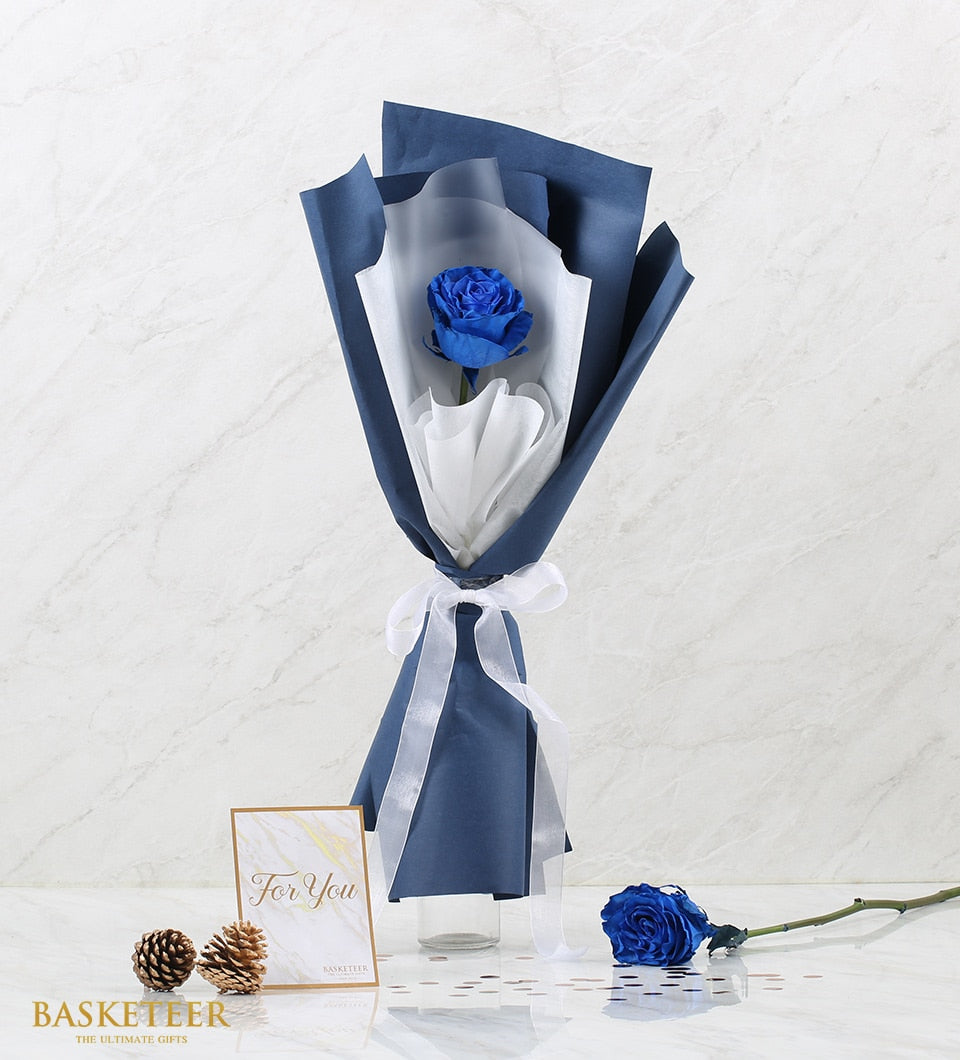 Single tinted blue Mondial rose with sheer wrap and white ribbon