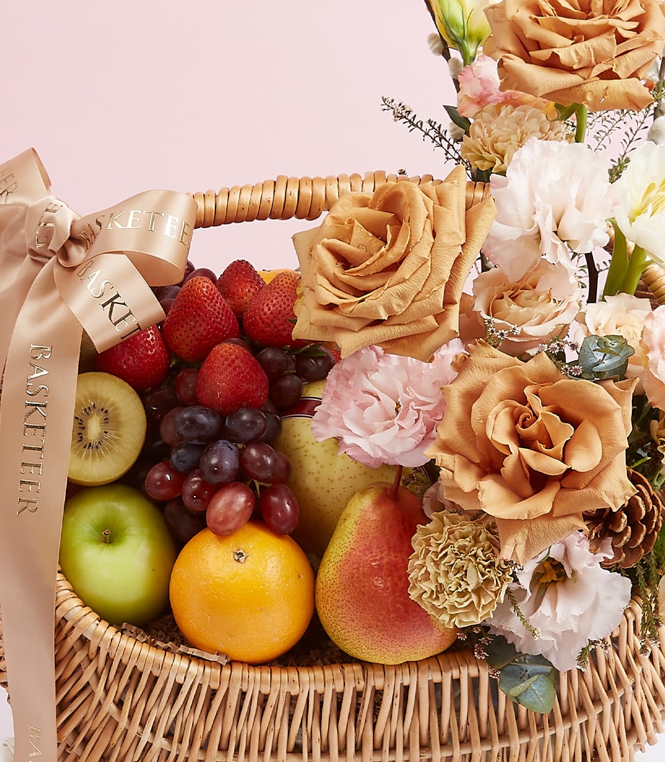 Premium fresh fruit and peach rose flower basket with strawberries, grapes, kiwi, and carnations