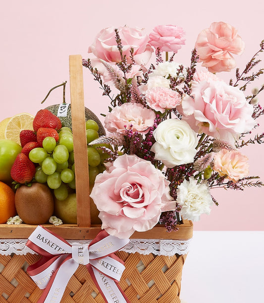 Mixed fruit and pink rose gift basket with strawberries, grapes, and fresh flowers for congratulations