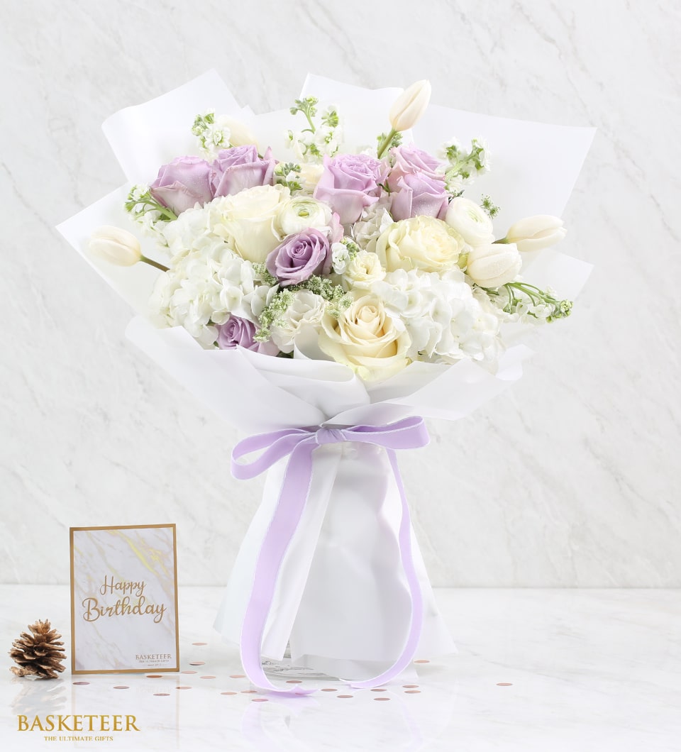Lavender and cream rose bouquet with white hydrangeas, tied with purple ribbon for Valentine's Day