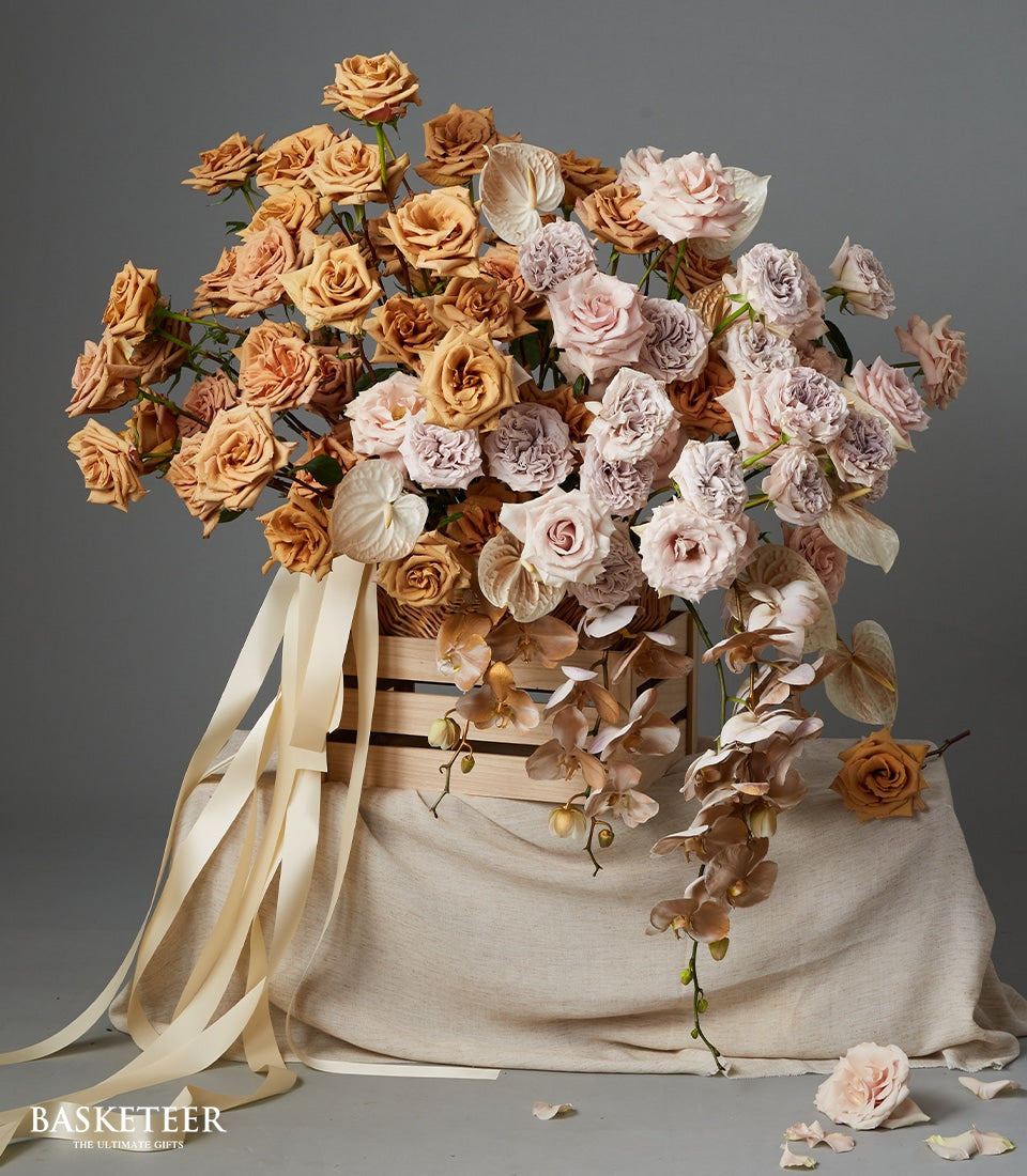 Luxury earth tone rose and orchid arrangement in wooden crate with cream ribbons