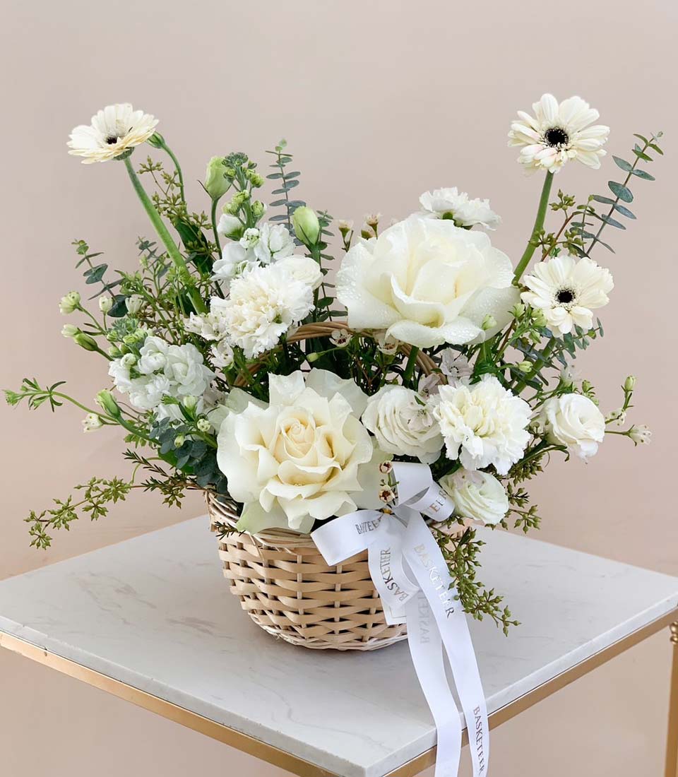 White rose and carnation graduation gift basket with eucalyptus greenery and silk ribbon