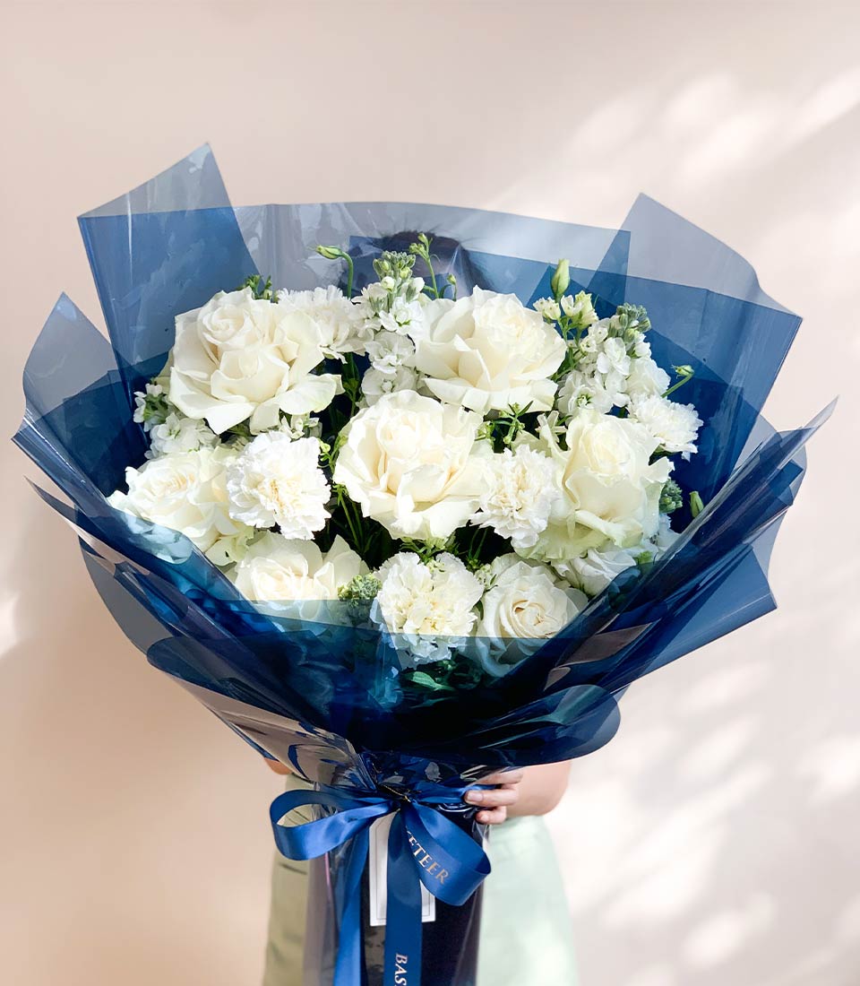 Elegant white roses and carnations bouquet with dark blue wrapping and satin ribbon