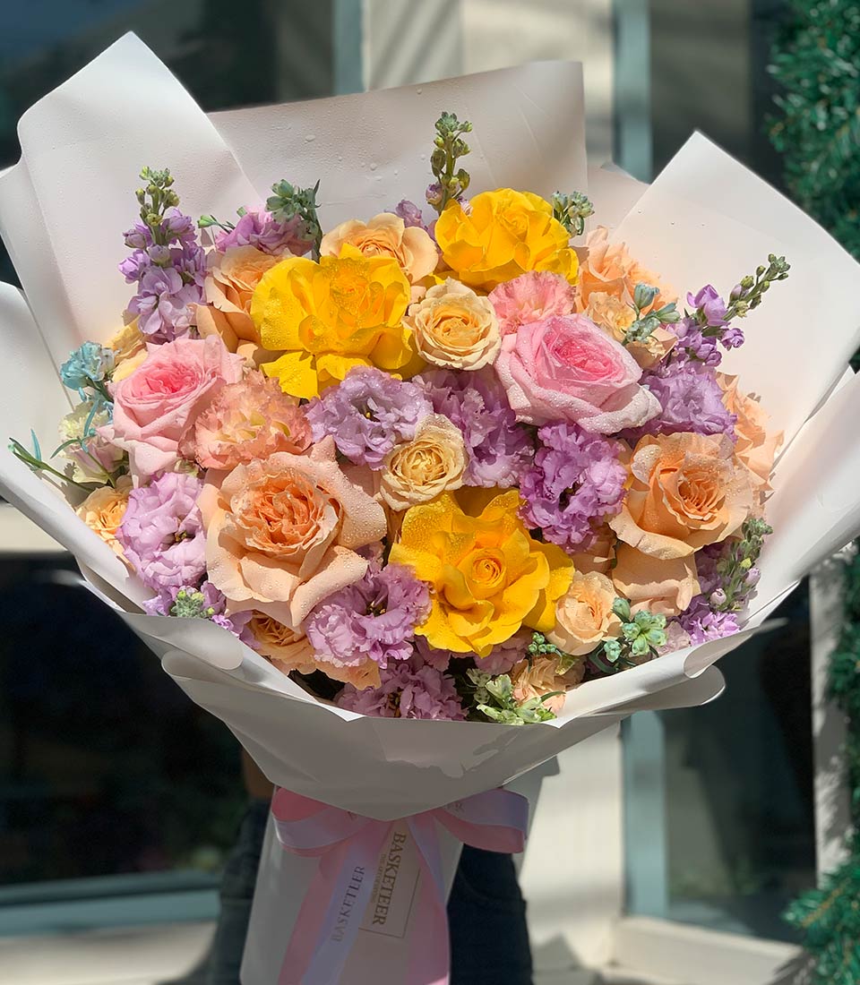 Soft Seasons Harmony Bouquet with yellow, pink, peach and purple roses for graduation celebration