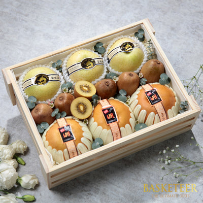 Wooden crate filled with fresh pears, kiwis, and greenery in premium gift presentation