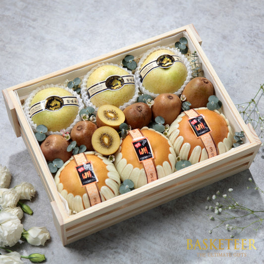 Wooden crate filled with fresh pears, kiwis, and greenery in premium gift presentation