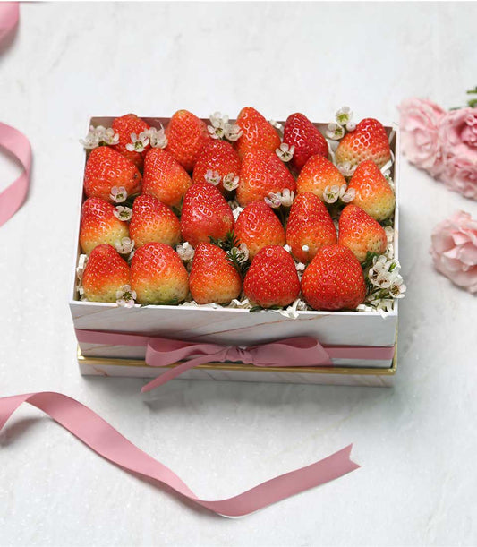 White marble gift box of fresh strawberries with pink satin ribbon, luxury fruit hamper for gifting