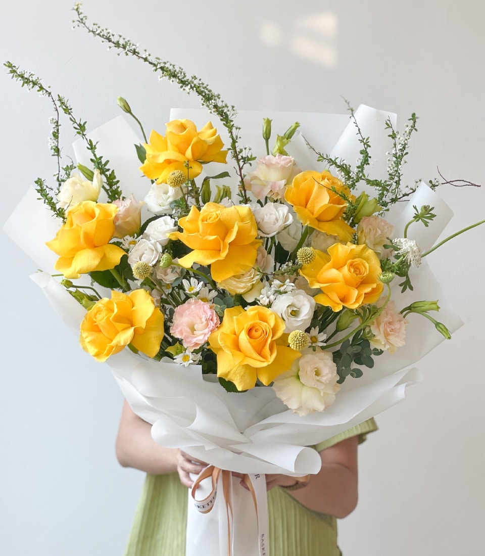 Sunny Serenity Rose Bouquet with yellow roses, white and pink blooms, green foliage, white ribbon wrap