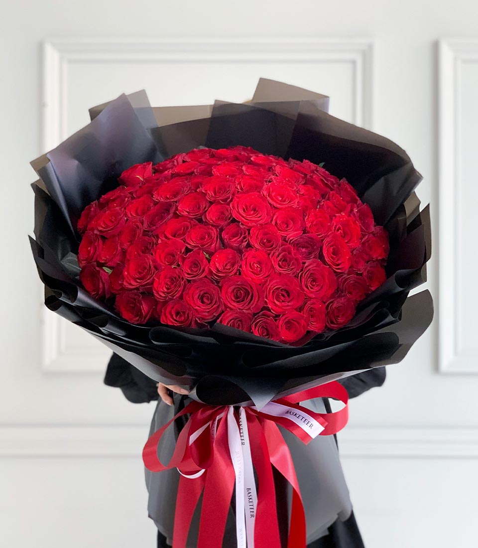 Luxurious red rose dome bouquet wrapped in dramatic black paper with red ribbon for Valentine's Day