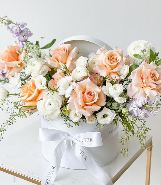 Peach and white fresh roses in white hatbox with satin ribbon bow, luxury birthday flower gift