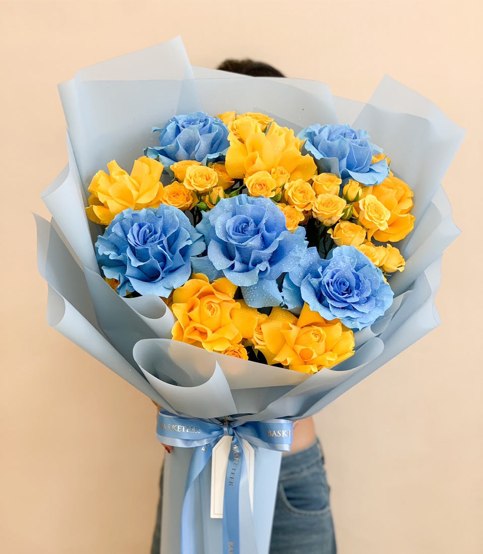 Blue and yellow roses graduation bouquet with light blue wrapping and ribbon