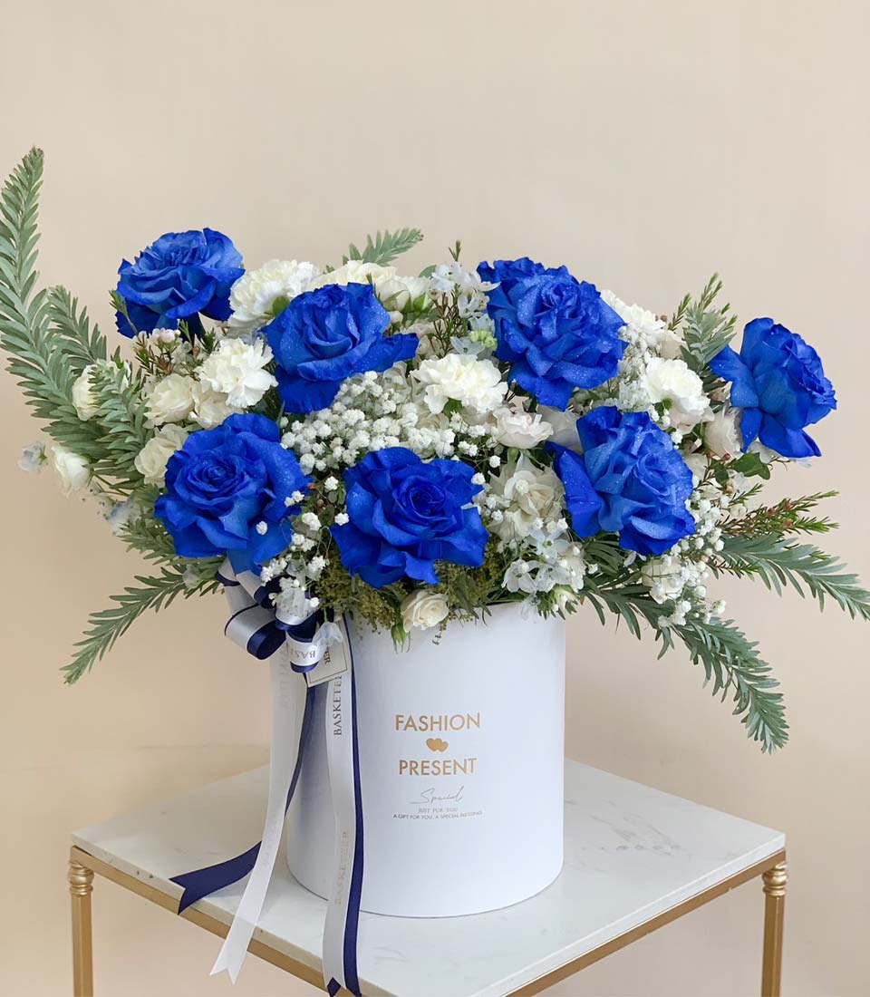 Blue rose and white carnation graduation flowers in premium white box with navy ribbon