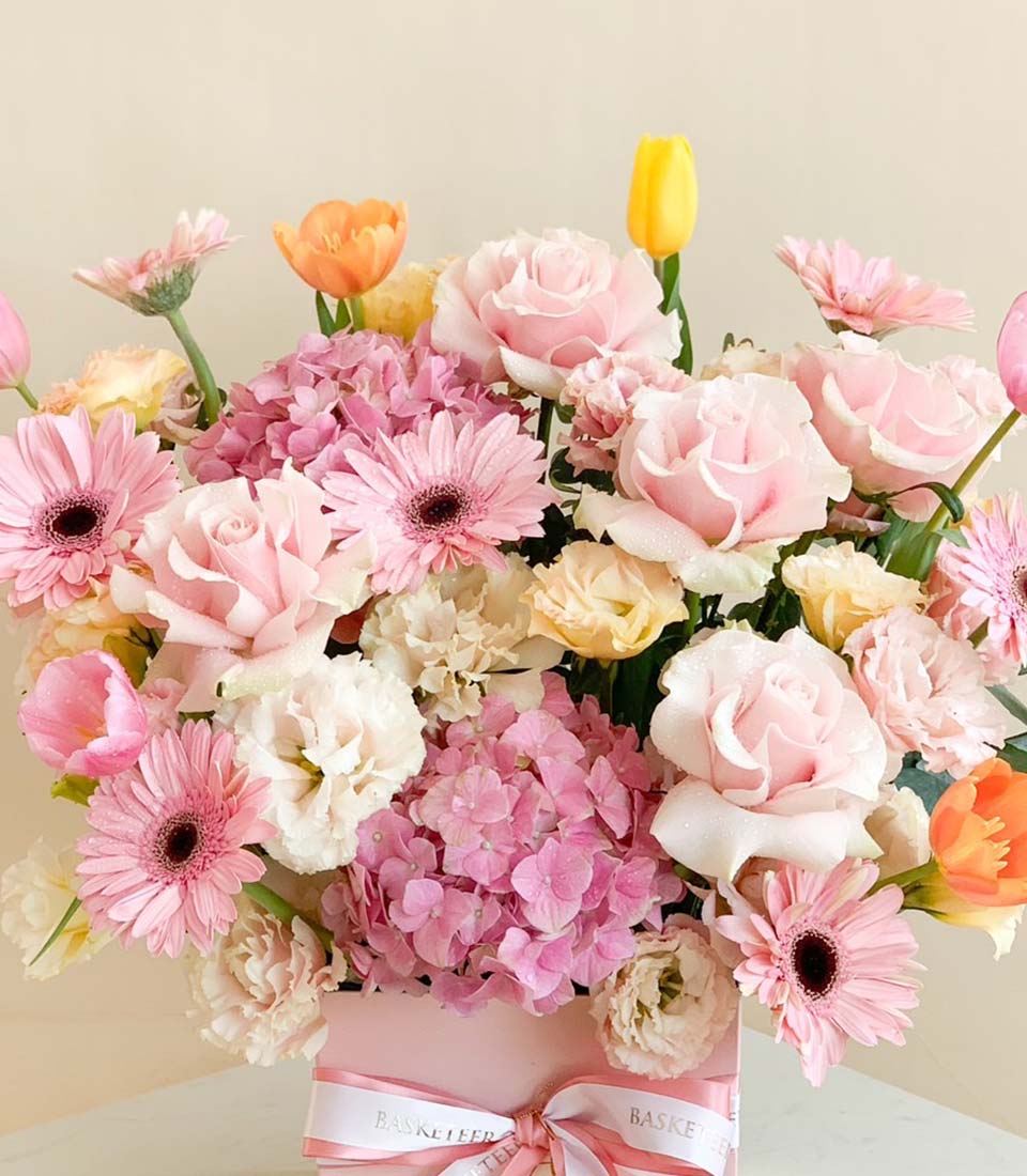 Luxury pink & pastel floral arrangement with roses, gerberas, hydrangeas, and tulips in light pink gift box with white