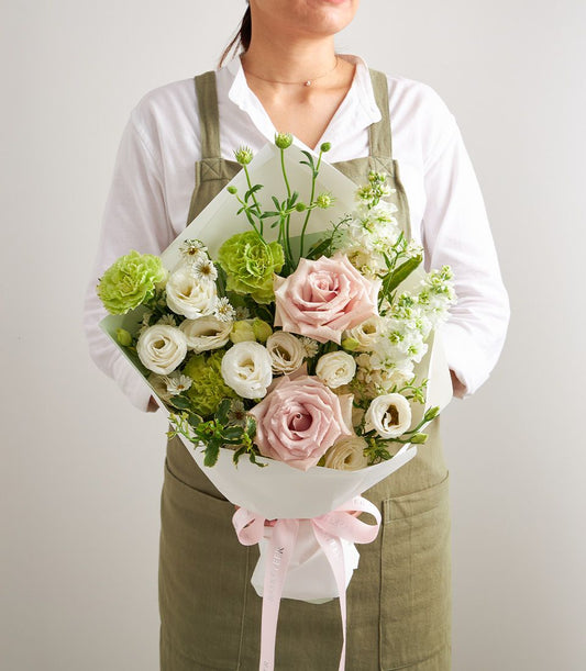 Blush Harmony petite bouquet of pink roses, white eustoma, and green carnations with pink ribbon