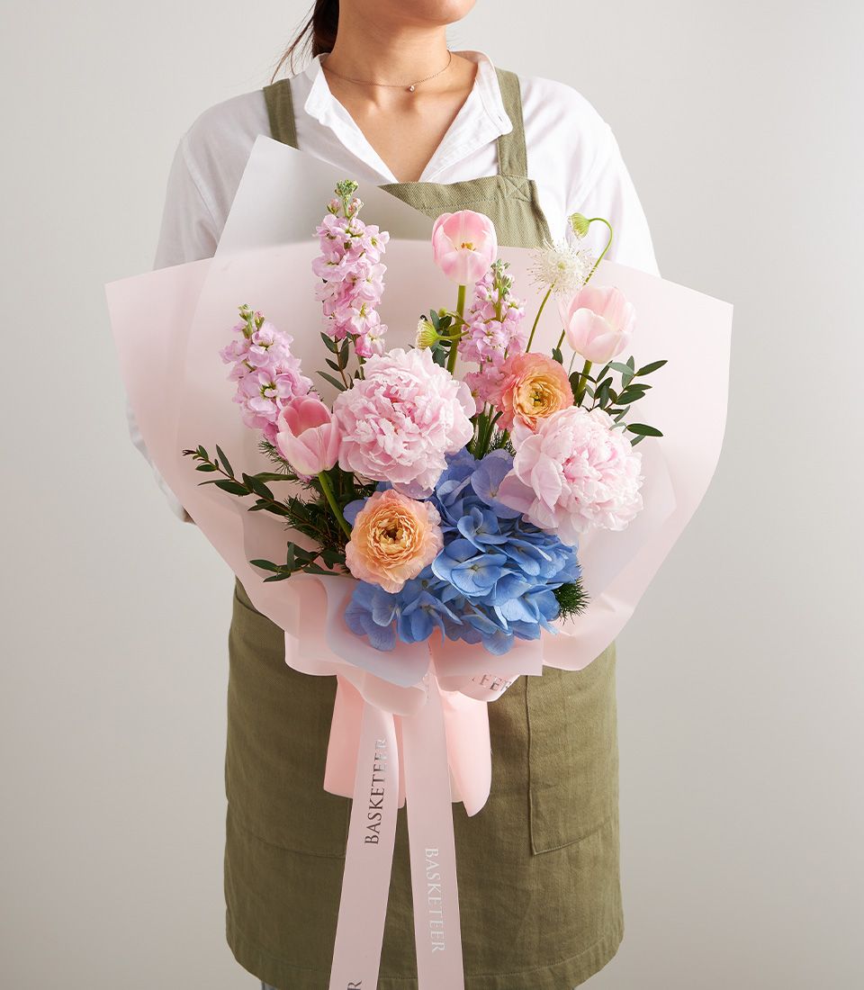 Premium blush pink peony and hydrangea bouquet with tulips and ranunculus, wrapped in pink paper with ribbon