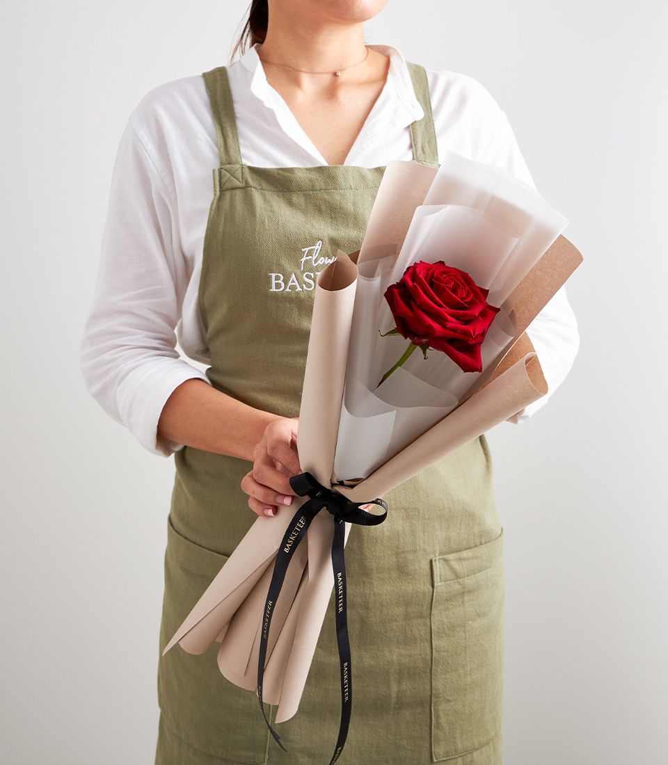 Single red rose wrapped in kraft paper with black Basketeer ribbon