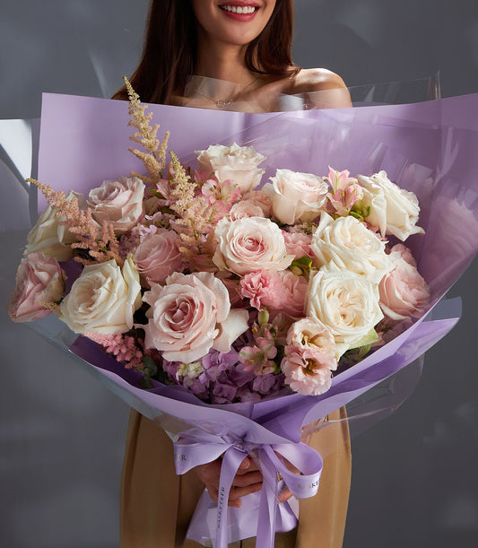 Large pink and white Ecuadorian rose bouquet with hydrangeas and astilbe, wrapped in purple cellophane