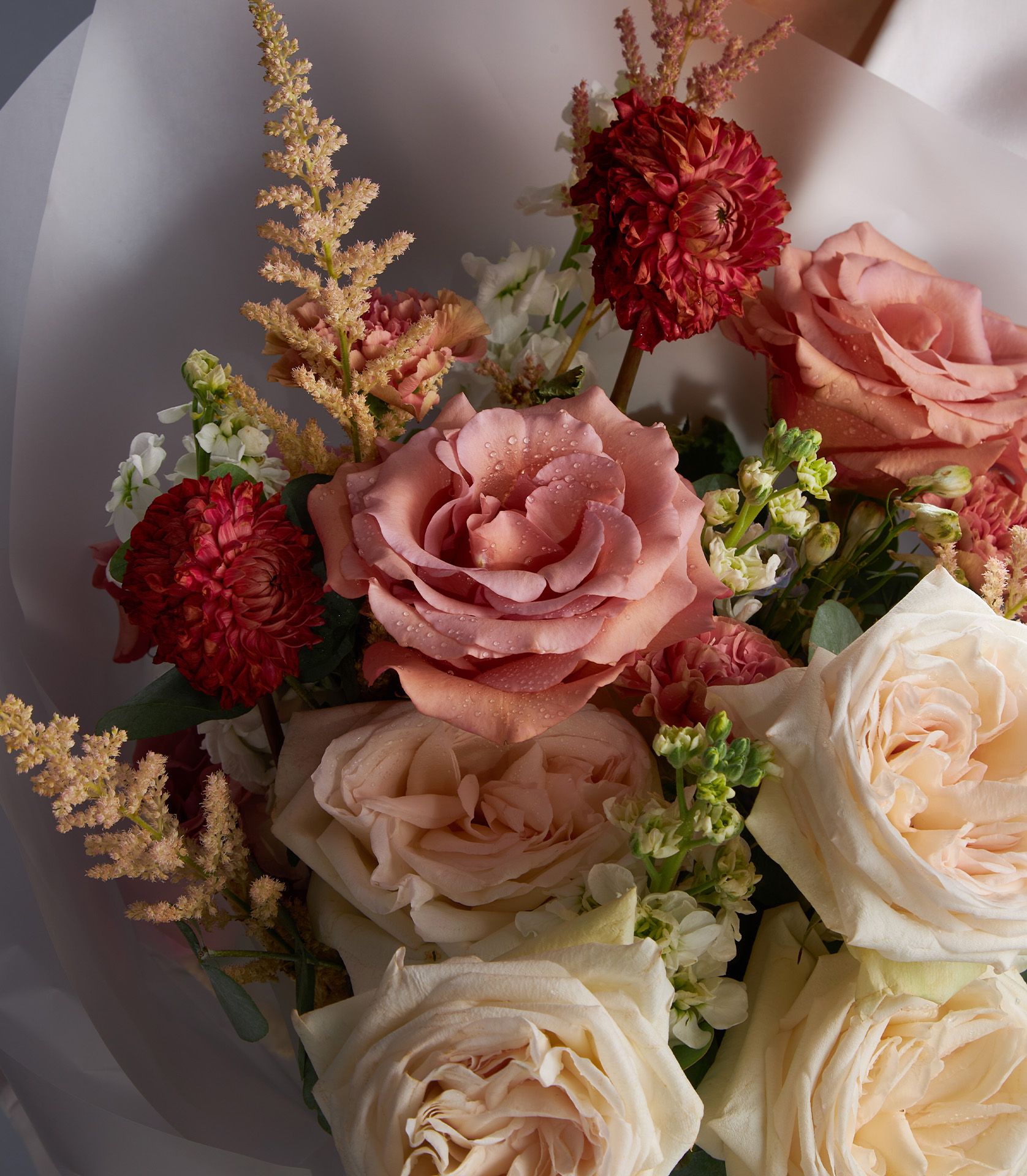Premium fresh rose bouquet with pink and red dahlias, white garden roses, and astilbe in elegant grey wrapping