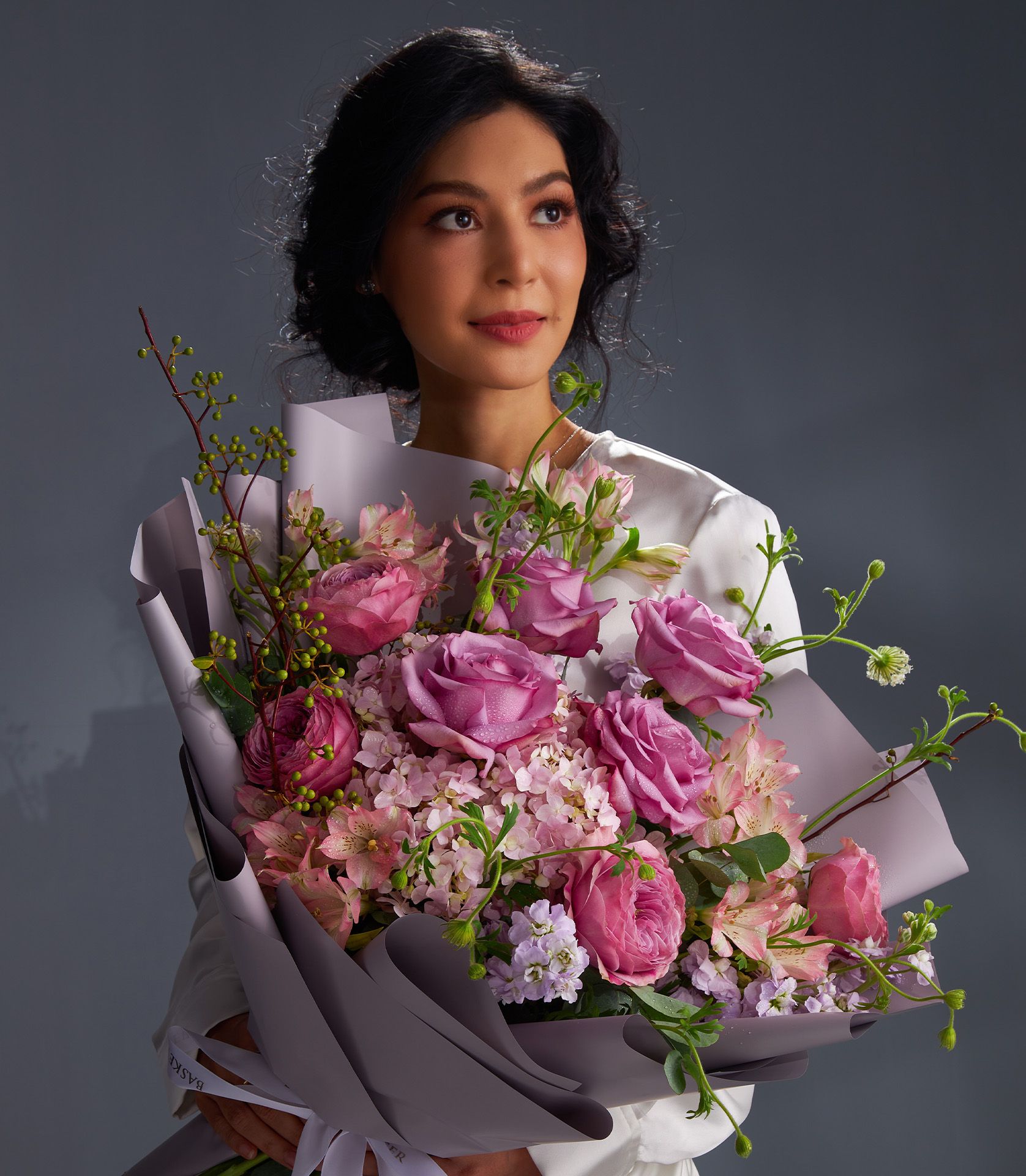 Mauve and blush rose bouquet with hydrangeas and fresh greenery, wrapped in purple paper