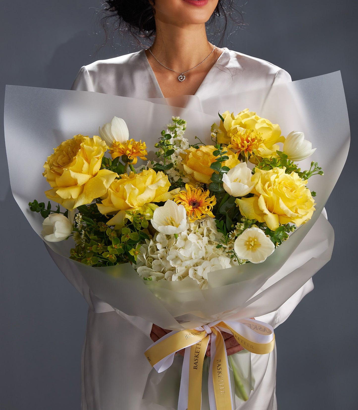 Vibrant yellow roses and white tulips bouquet with gold and white Basketeer ribbon