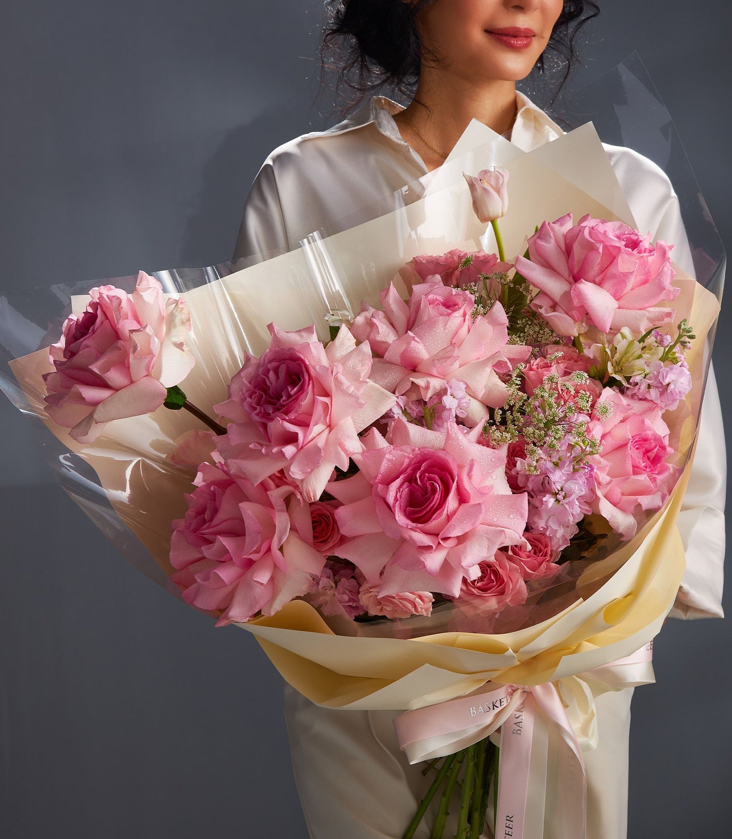 Elegant pink rose bouquet with cream wrapping and ribbon, fresh Ecuador roses with water droplets