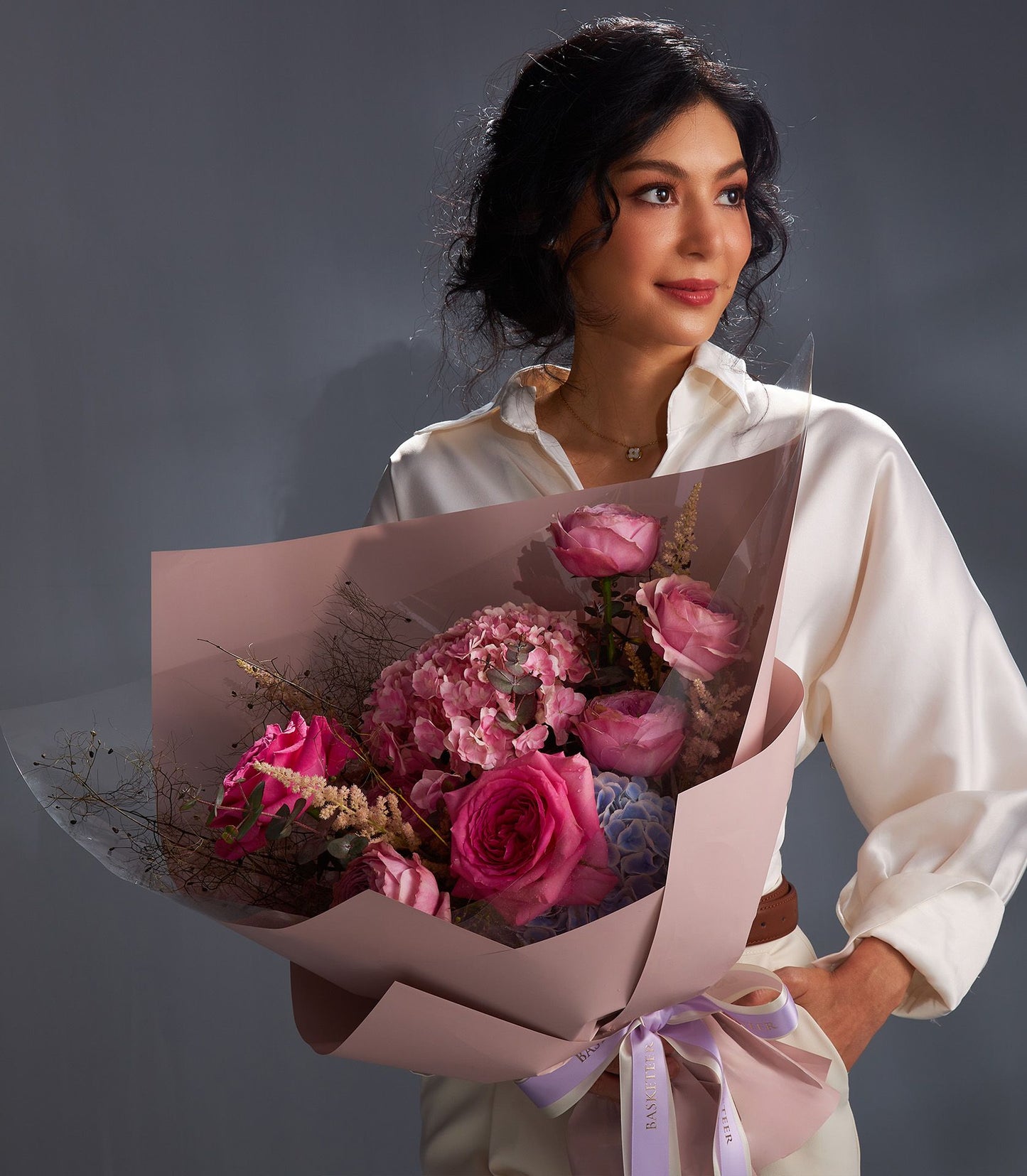Pink rose and hydrangea luxury bouquet wrapped in matte pink paper with purple ribbon