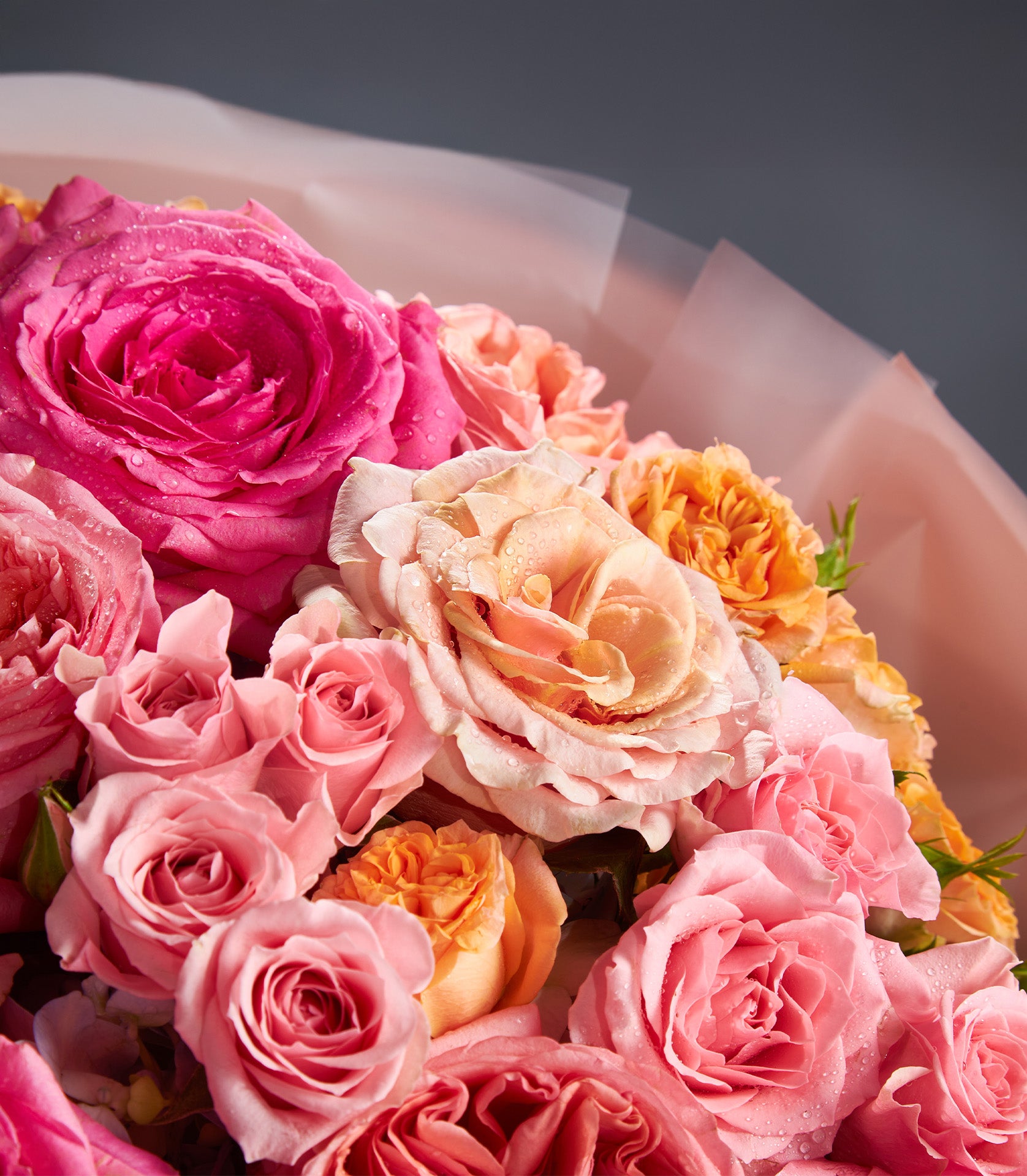 Fresh pink and orange rose bouquet wrapped in peach paper, ideal for anniversary celebrations