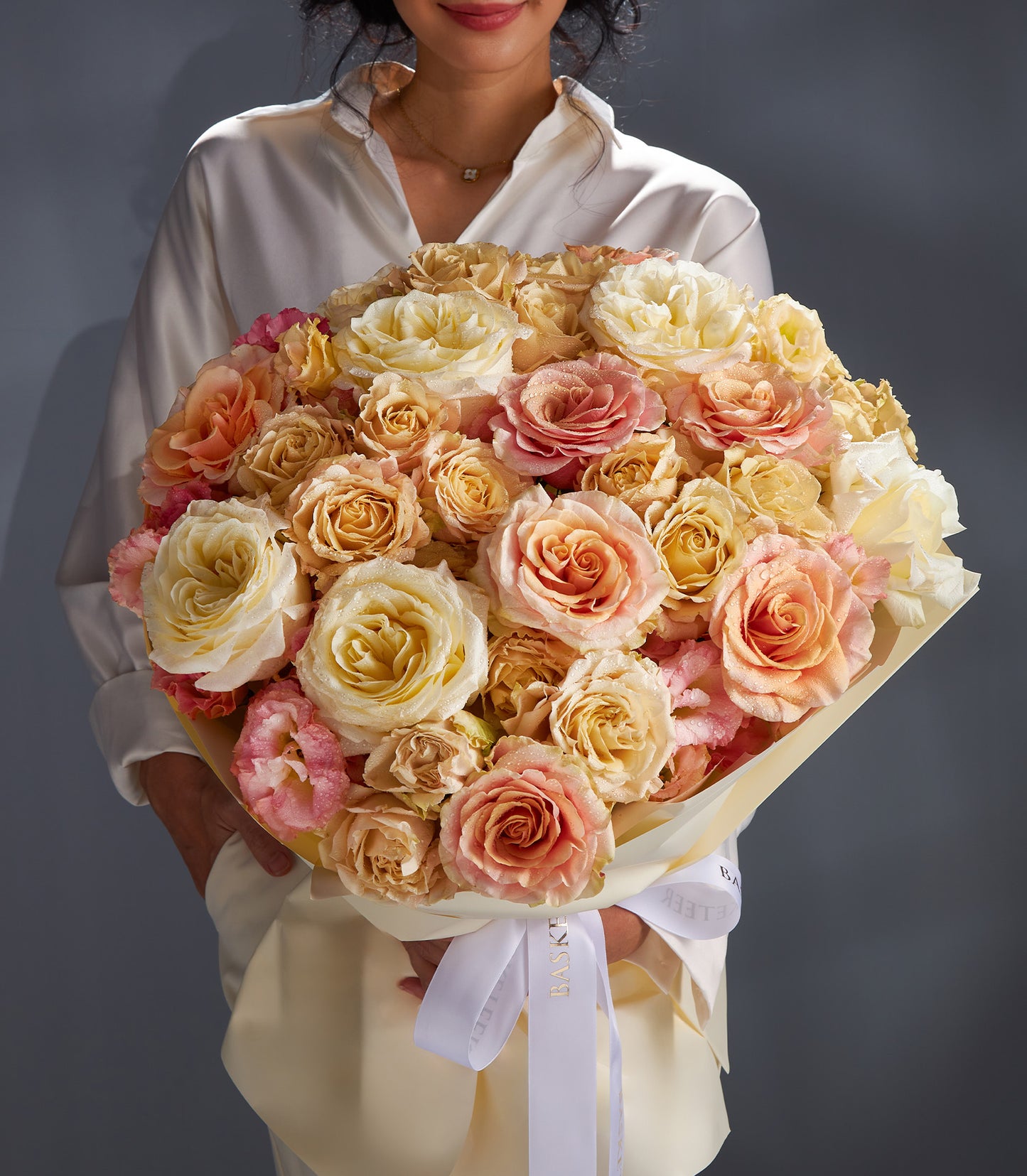 Warm cream and blush rose bouquet tied with white satin ribbon for anniversaries and special celebrations