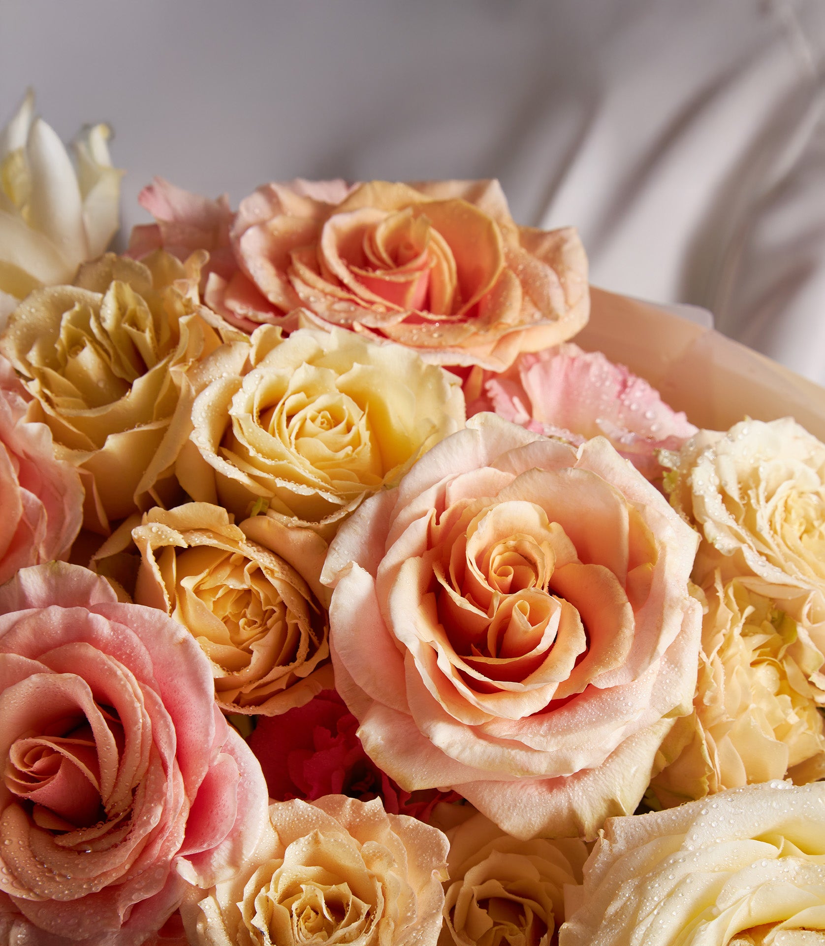 Warm cream rose bouquet with peach, pink, and yellow roses for anniversaries