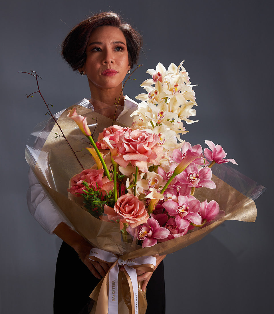 Luxury bouquet of pink roses, white orchids, and calla lilies with white ribbon wrap