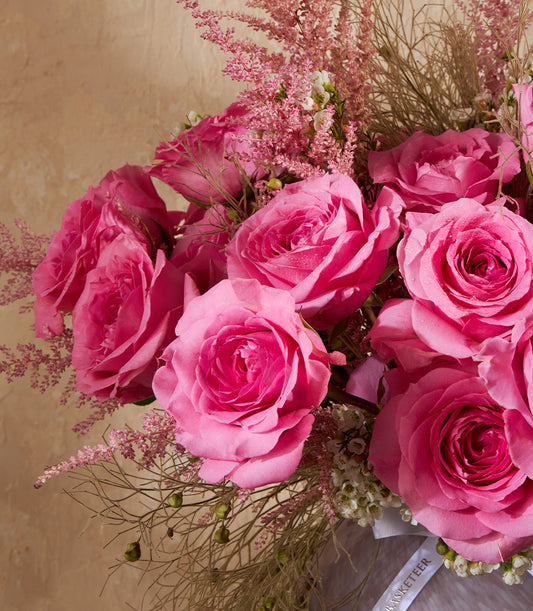 Lush pink rose bouquet with astilbe and berry branches in premium gift arrangement