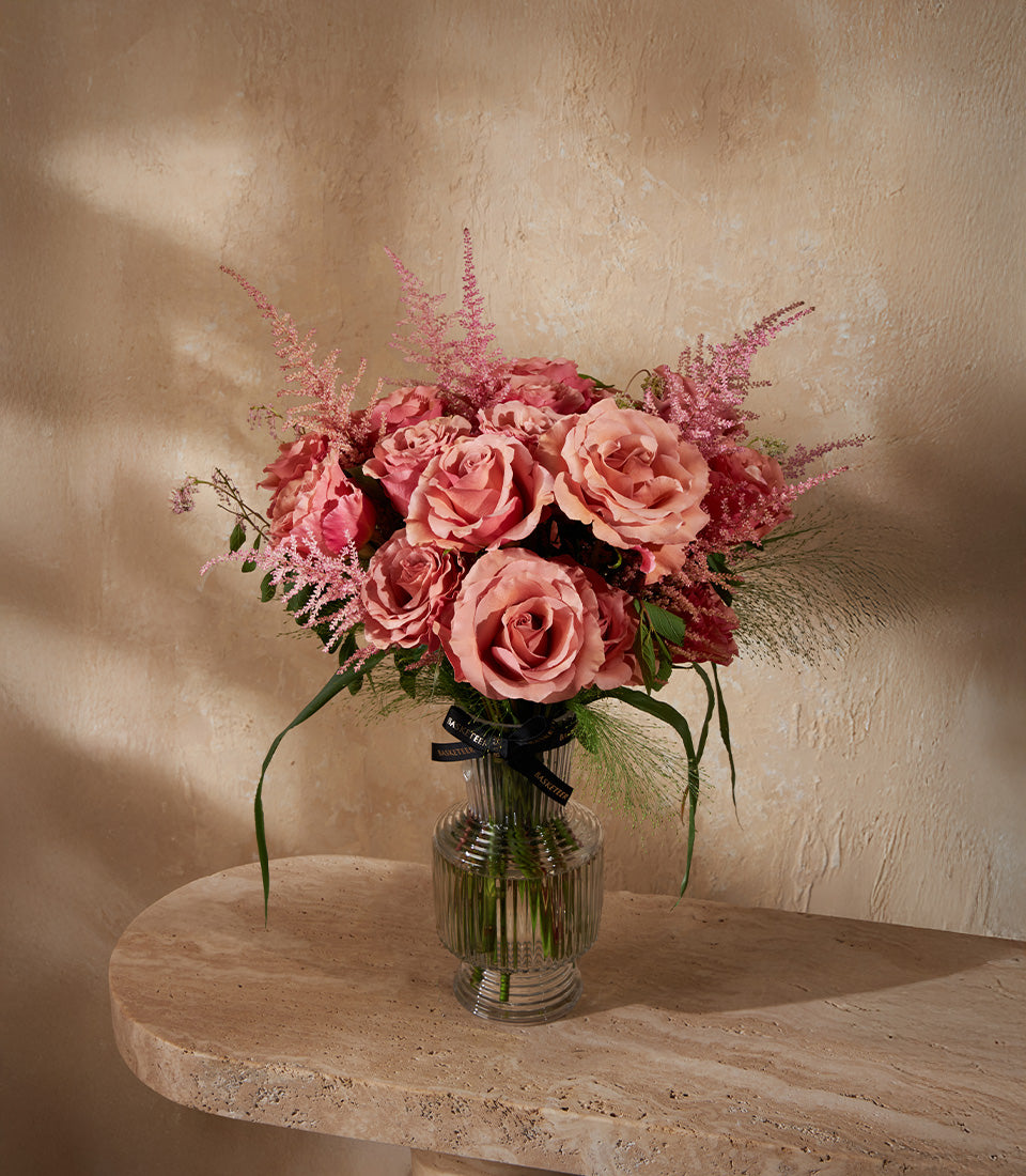 Blush pink roses and astilbe in ribbed glass vase with black ribbon, premium fresh flower arrangement
